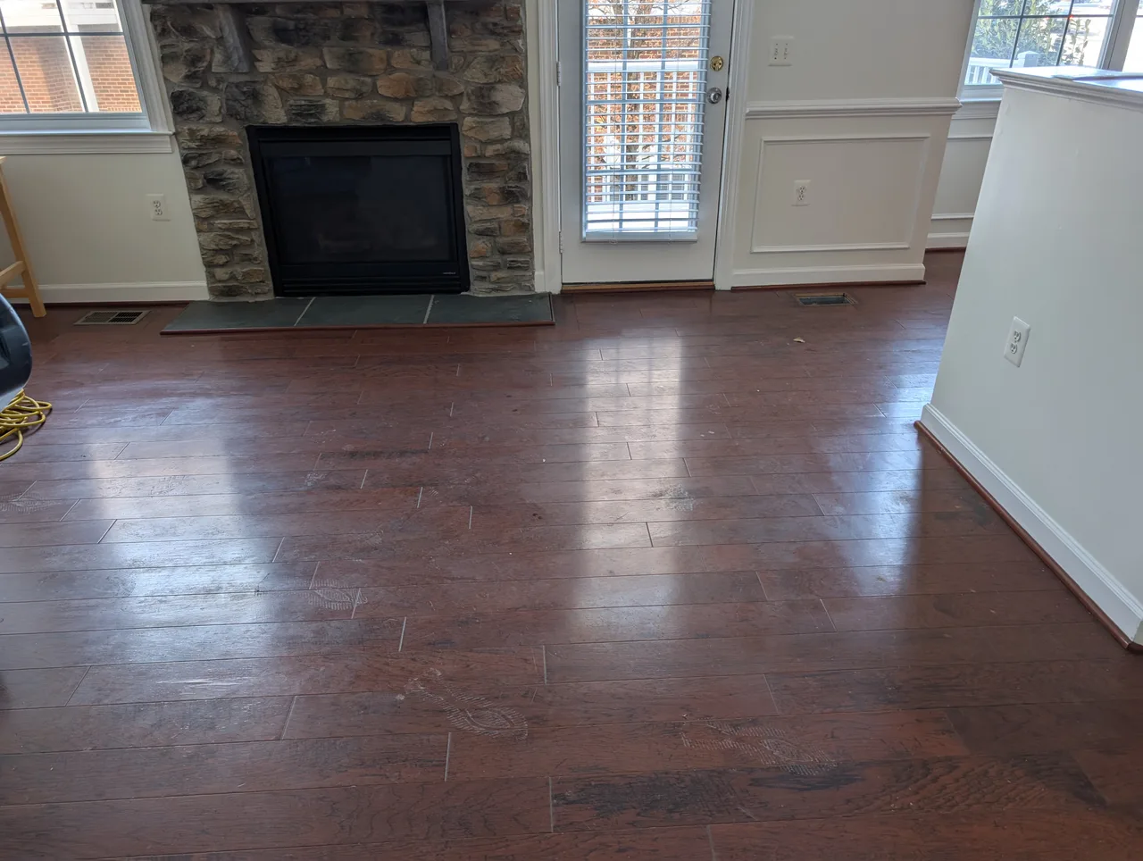 Hardwood floor before cleaning, dull with visible dirt and scuff marks